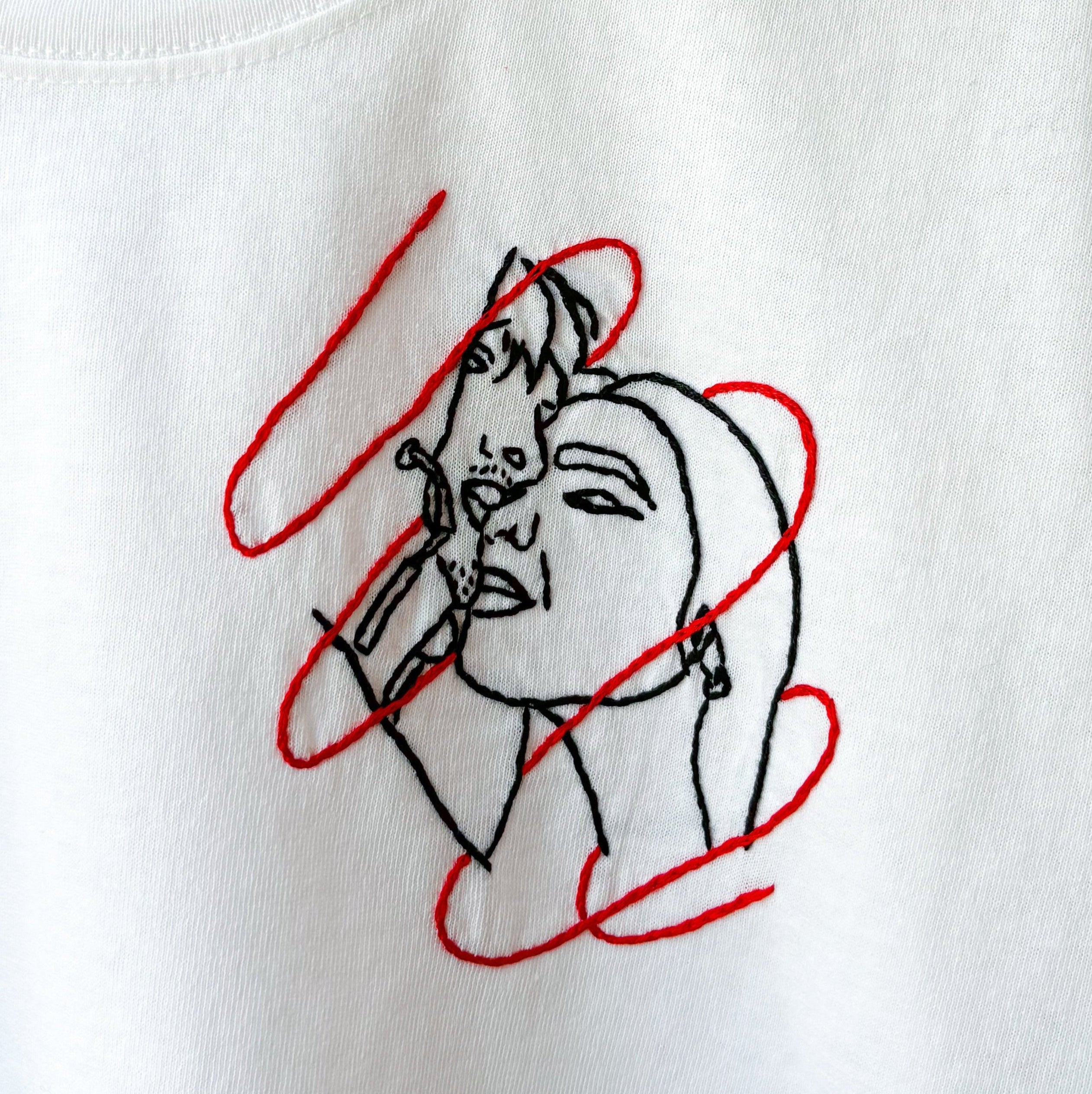 Maglietta ricamata a mano e personalizzata con la foto di due persone avvolte in un filo rosso. Ispirata alla leggenda giapponese del filo rosso.